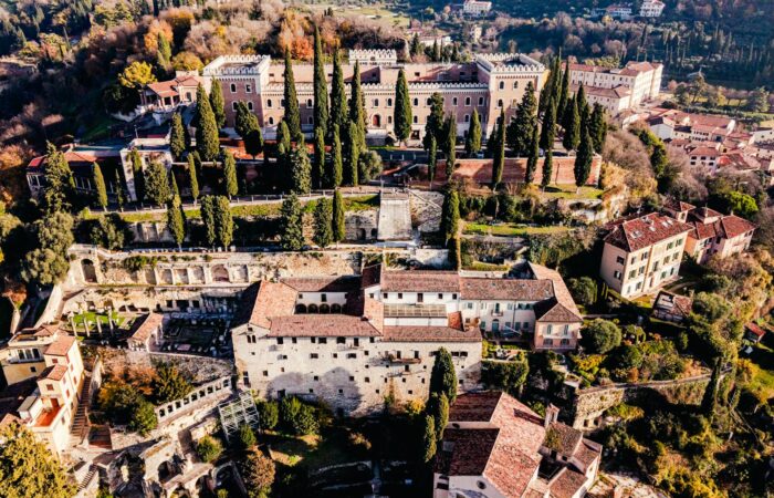 Stunning aerial view of historic castles and greenery in Verona, Italy.