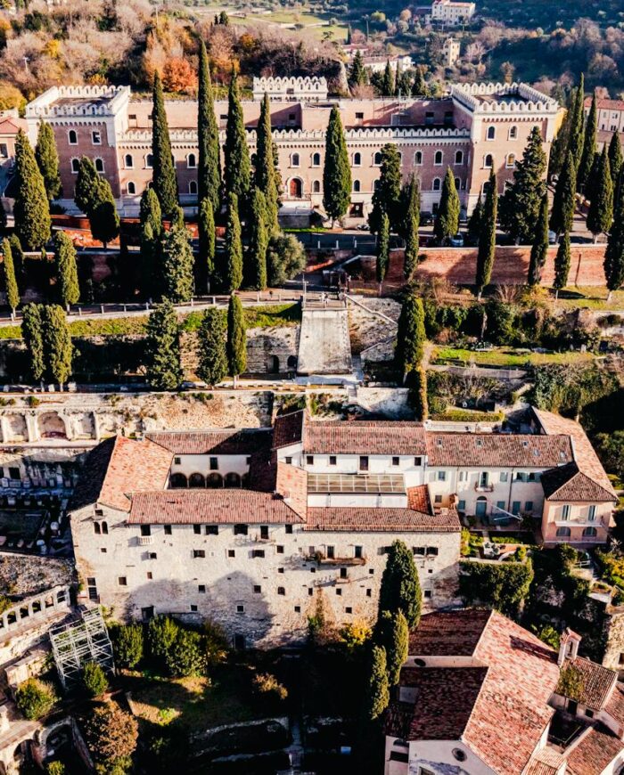 Stunning aerial view of historic castles and greenery in Verona, Italy.