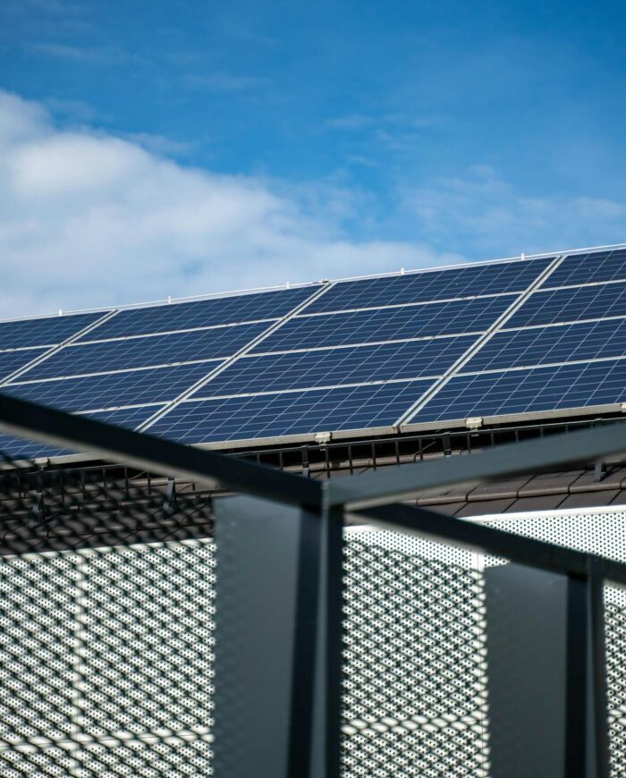 Close-up view of modern solar panels on a rooftop against a clear blue sky, representing clean energy.
