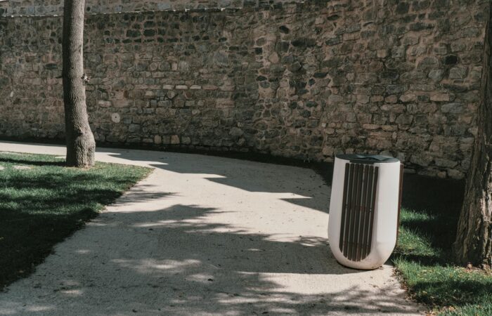 A tranquil path along a stone wall in a sunlit Istanbul park, showcasing nature and architecture.