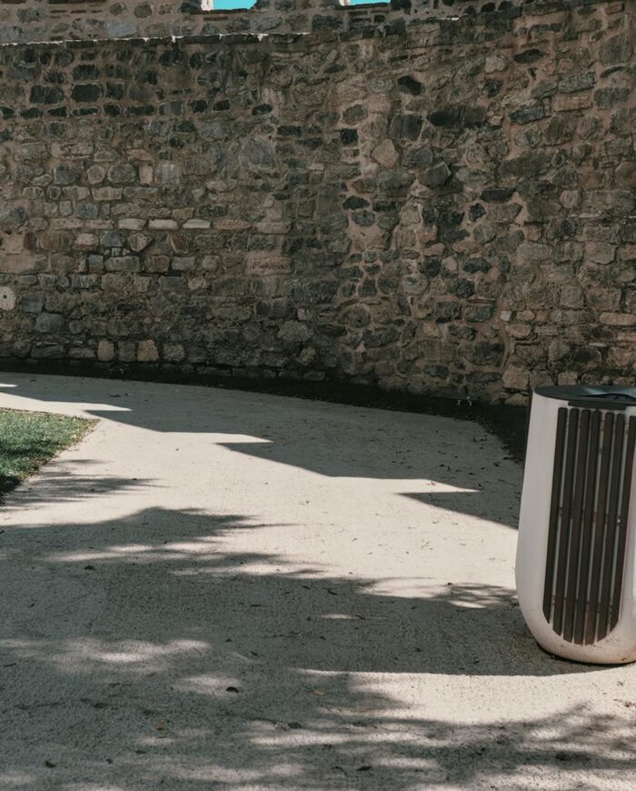 A tranquil path along a stone wall in a sunlit Istanbul park, showcasing nature and architecture.