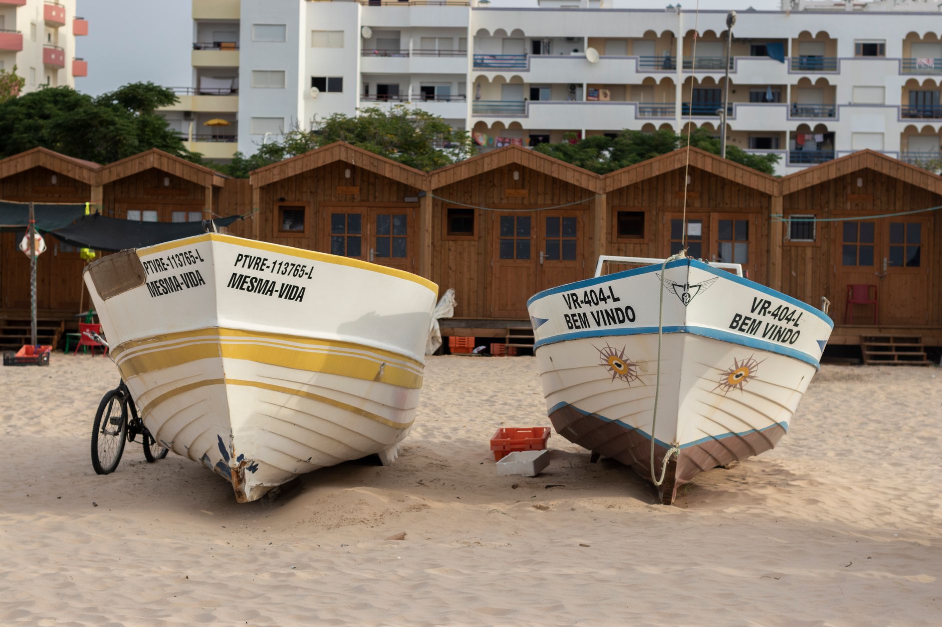 Colorful fishing boats resting on sandy Monte Gordo beach, Faro, Portugal.