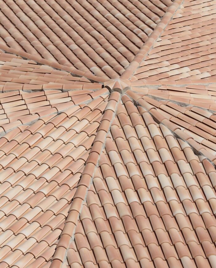 Detailed view of terracotta roof shingles forming a geometric pattern from above.