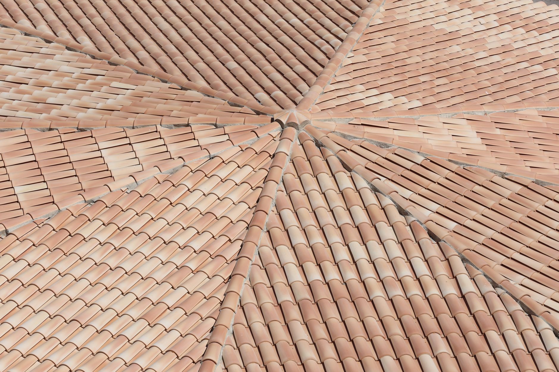 Detailed view of terracotta roof shingles forming a geometric pattern from above.