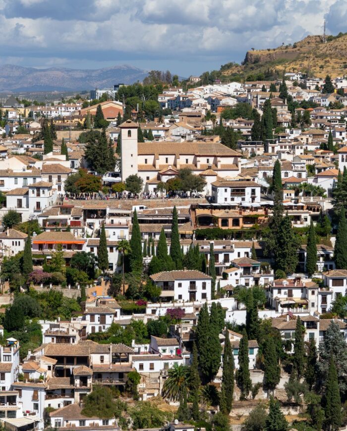 Explore Granada's historic charm with this panoramic view of its traditional architecture set against the Sierra Nevada mountains.