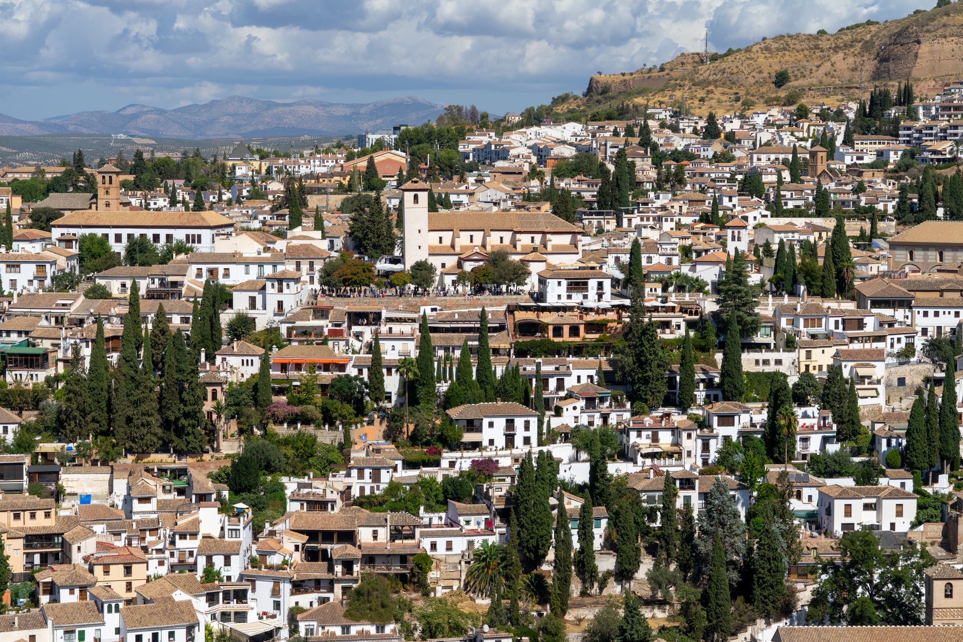 Explore Granada's historic charm with this panoramic view of its traditional architecture set against the Sierra Nevada mountains.