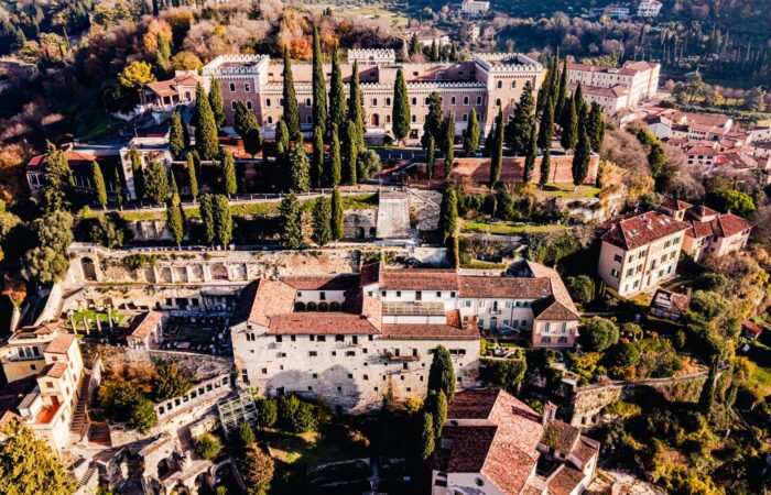 Stunning aerial view of historic castles and greenery in Verona, Italy.