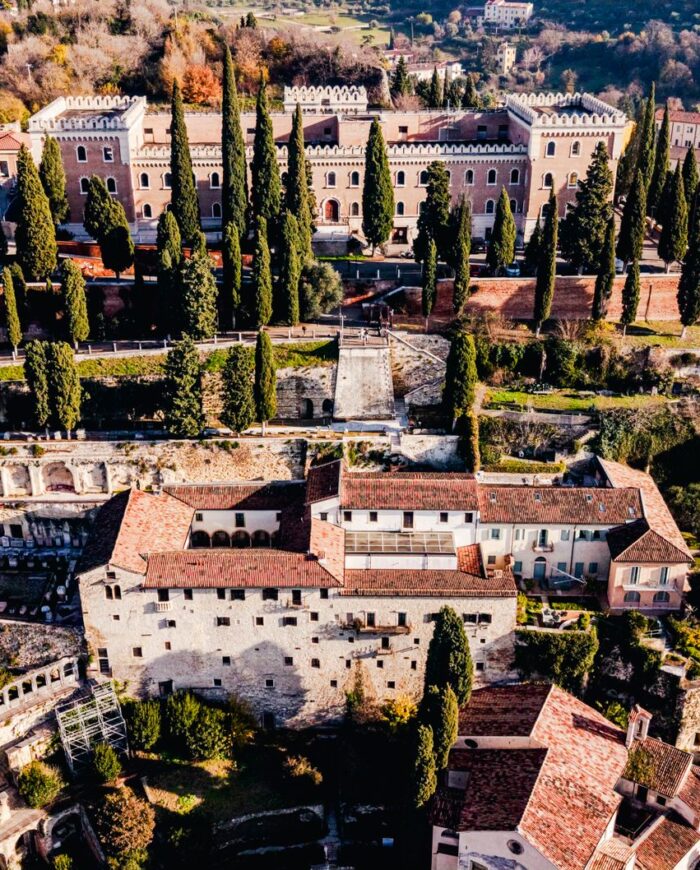 Stunning aerial view of historic castles and greenery in Verona, Italy.