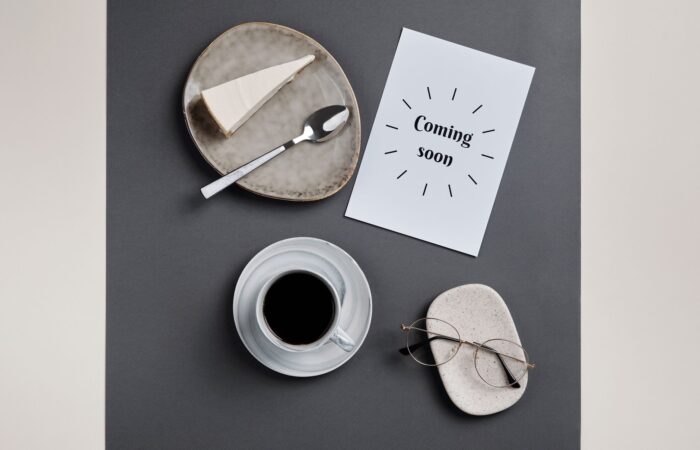 Stylish flatlay featuring coffee, slice of cheesecake, and eyeglasses on paper. Stylish flatlay featuring coffee, slice of cheesecake, and eyeglasses on paper.