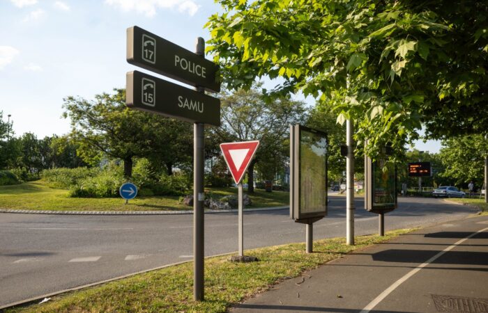 Roundabout in France with traffic signs and lush greenery on a sunny day. Roundabout in France with traffic signs and lush greenery on a sunny day.